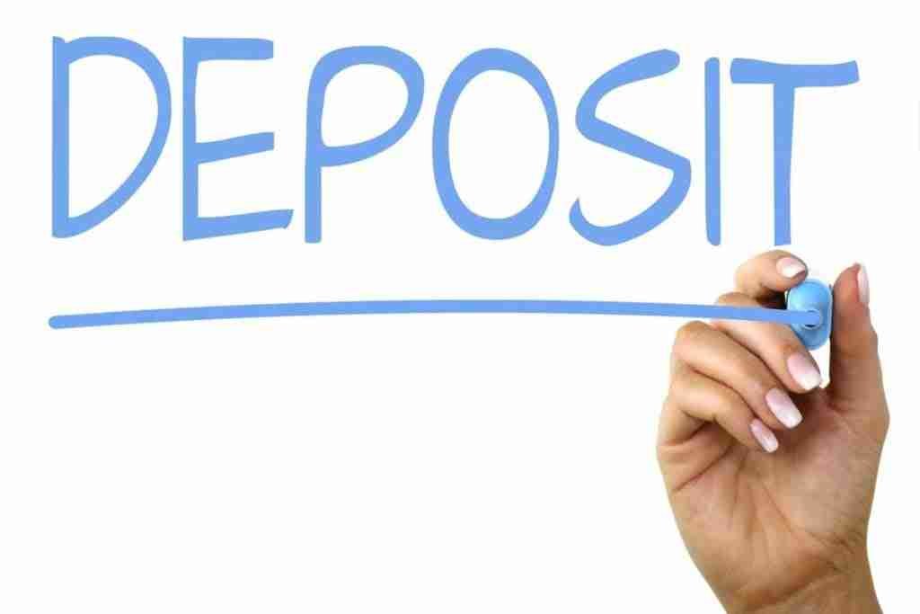 Hand with pen writing the word "deposit" with an underscore line, depicting the concept of banking or saving. Contract Phones No Credit Check No Deposit