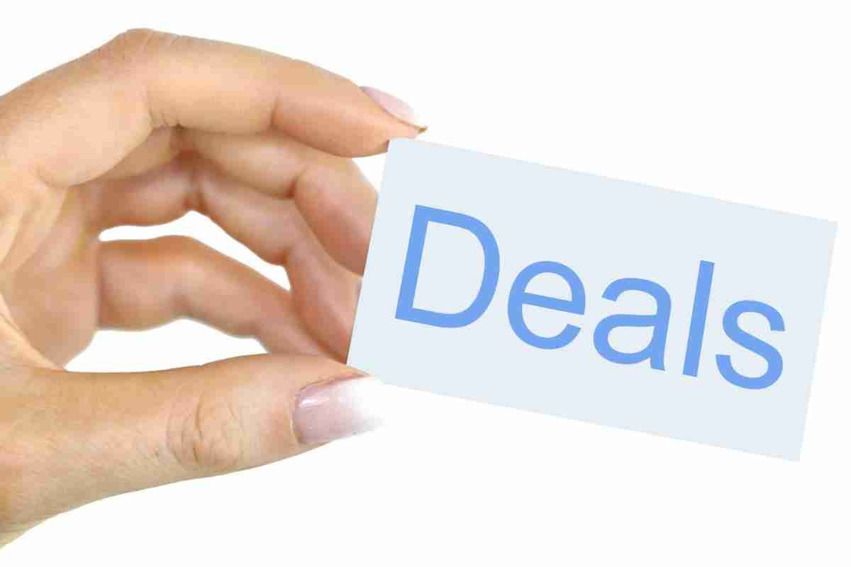 Hand holding a small card with the word 'deals' written on it, showcasing offers or savings opportunities. mobile phone deals