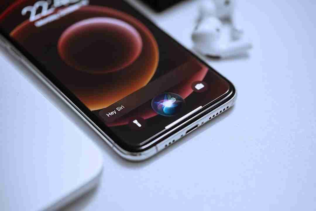 A smartphone showcasing the evolution of mobile phones with a voice assistant activation on screen, placed next to a pair of earbuds, highlighting modern communication technology.