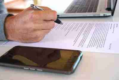 easiest contract phones man working at desk with laptop and mobile