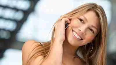 A smiling woman having a pleasant conversation on her mobile phone. mobile phone finance bad credit